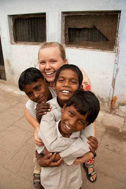 Children hugging a volunteer at SSS Anandvan